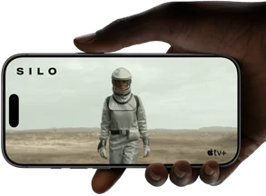 A hand holds an iPhone 17 Pro, Silver, horizontal, video playback on all-screen display demonstrating battery life